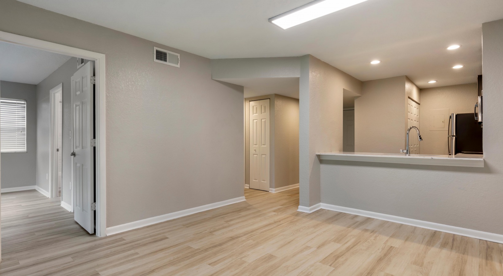 empty room with hardwood floors and light gray walls at The Marino