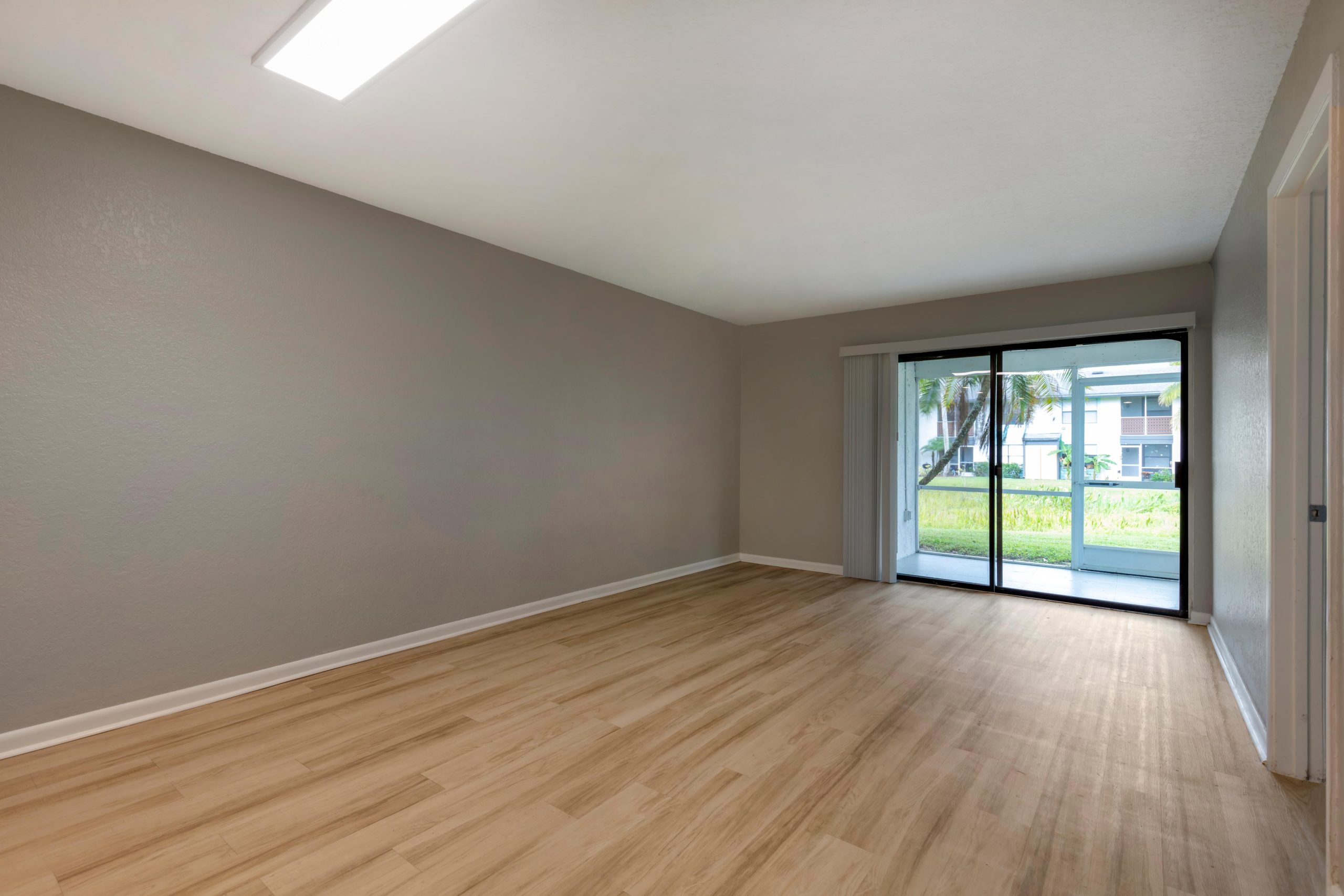 empty room with sliding glass doors and hardwood floors at The Marino
