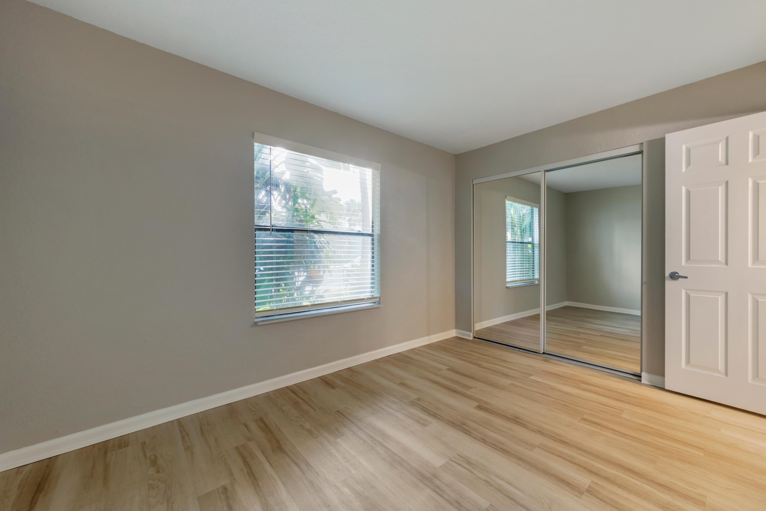 empty room with hardwood floors and sliding glass doors at The Marino