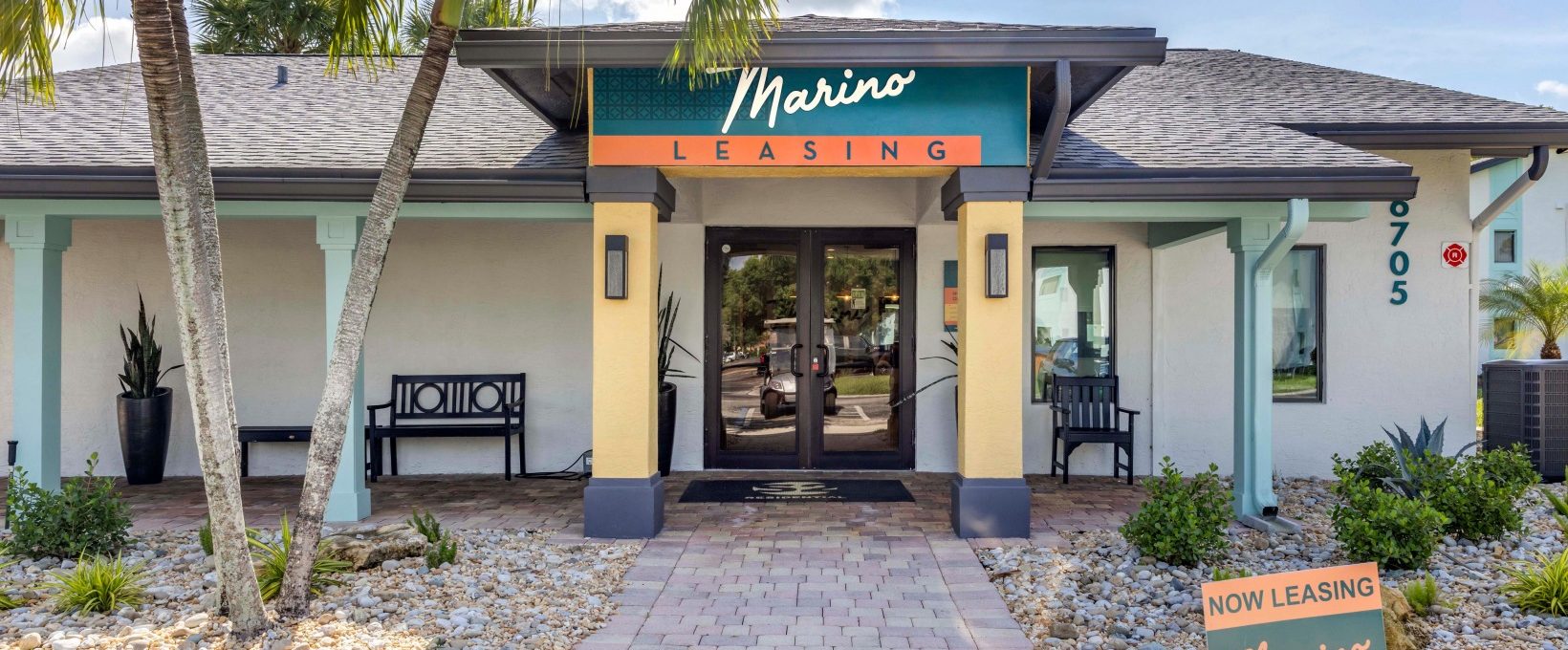 the front entrance to a business with palm trees and a sign that says marina at The Marino