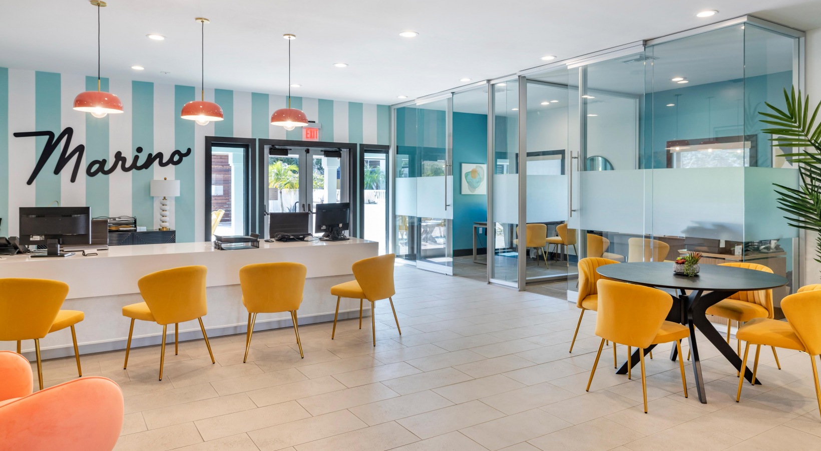 a lobby with orange chairs and a blue table at The Marino