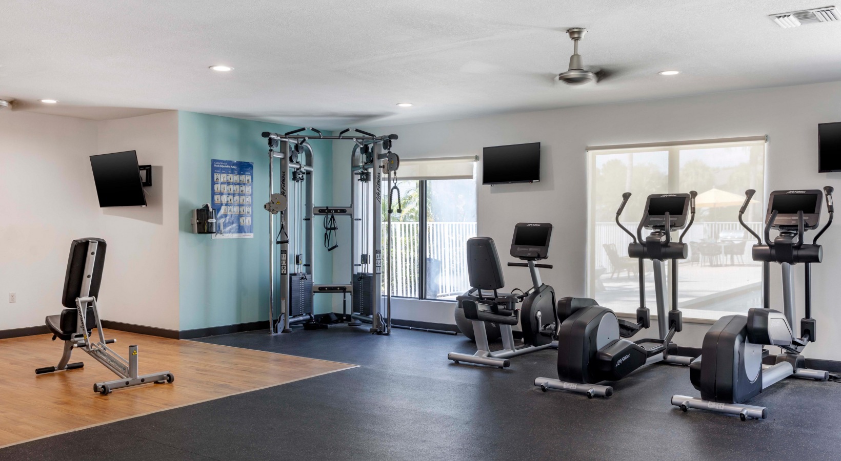 a gym room with exercise equipment and television at The Marino