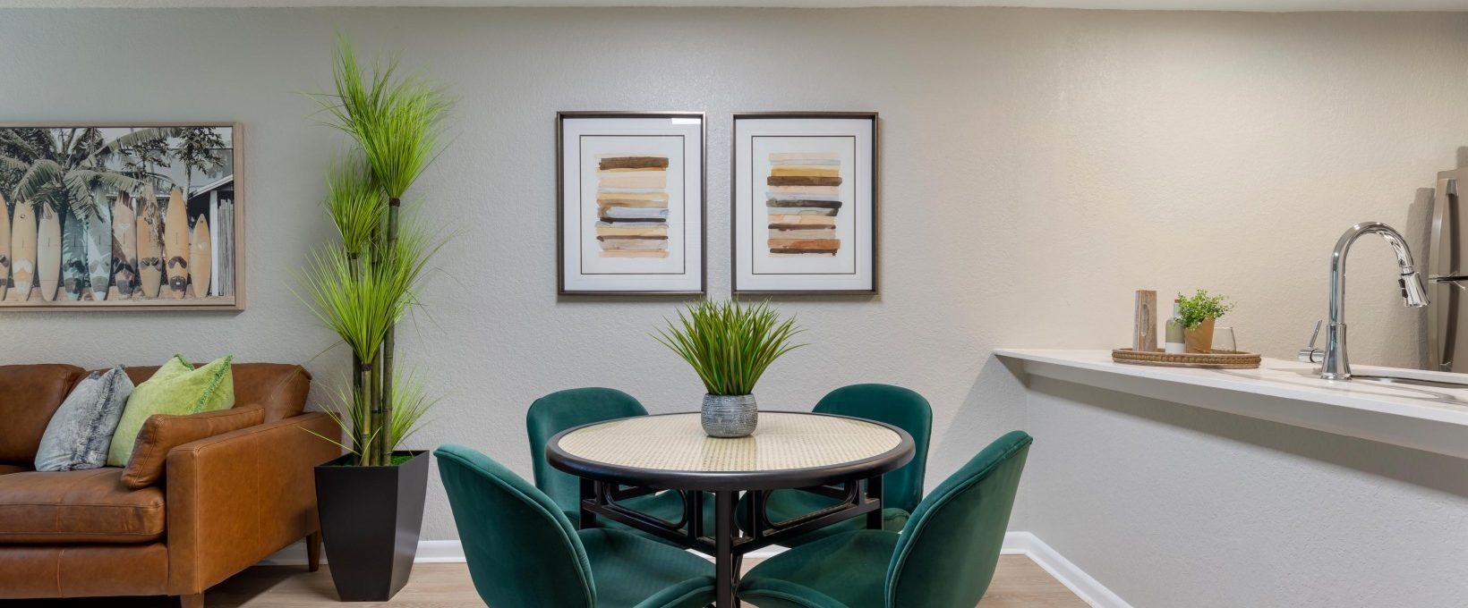 a dining room and kitchen area with green chairs at The Marino
