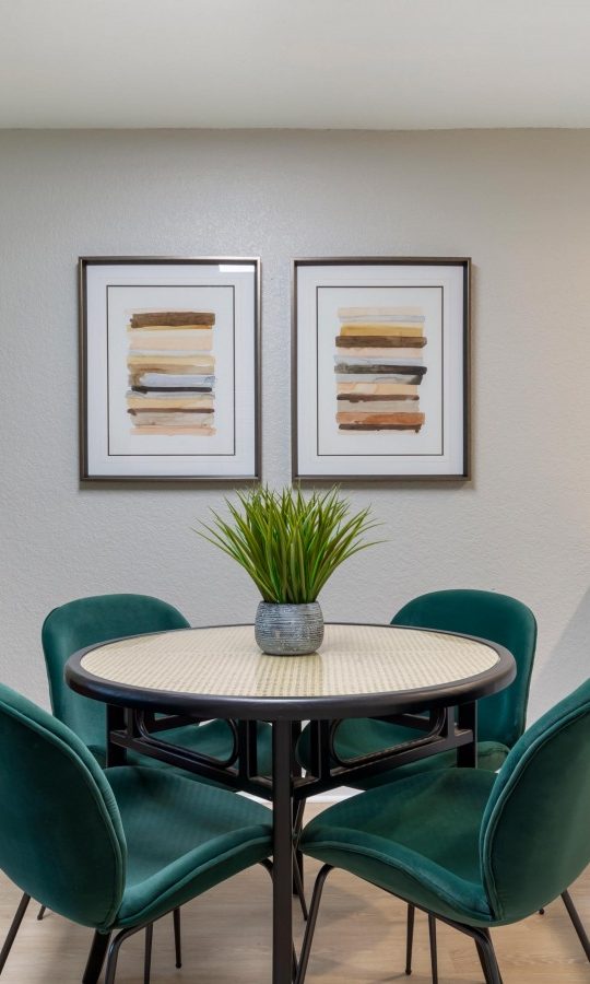 a dining room and kitchen area with green chairs at The Marino