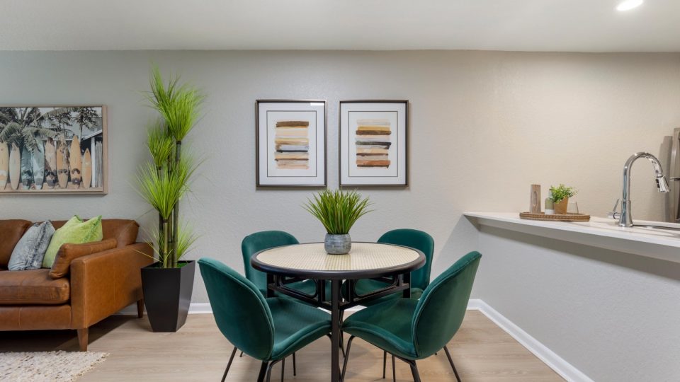 a dining room and kitchen area with green chairs at The Marino