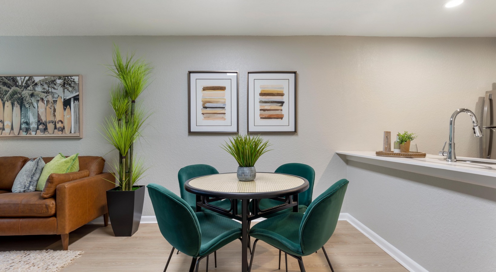a dining room and kitchen area with green chairs at The Marino