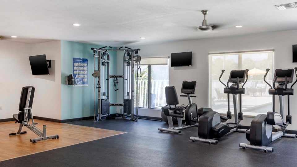 a gym room with exercise equipment and television at The Marino