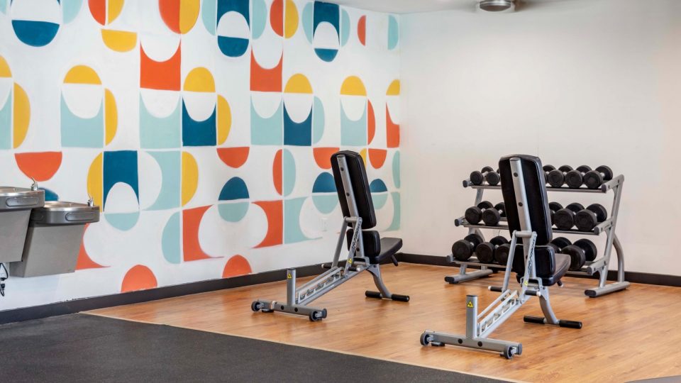 a gym room with a colorful wall mural at The Marino